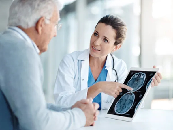 Doctor reviewing brain scan with senior patient